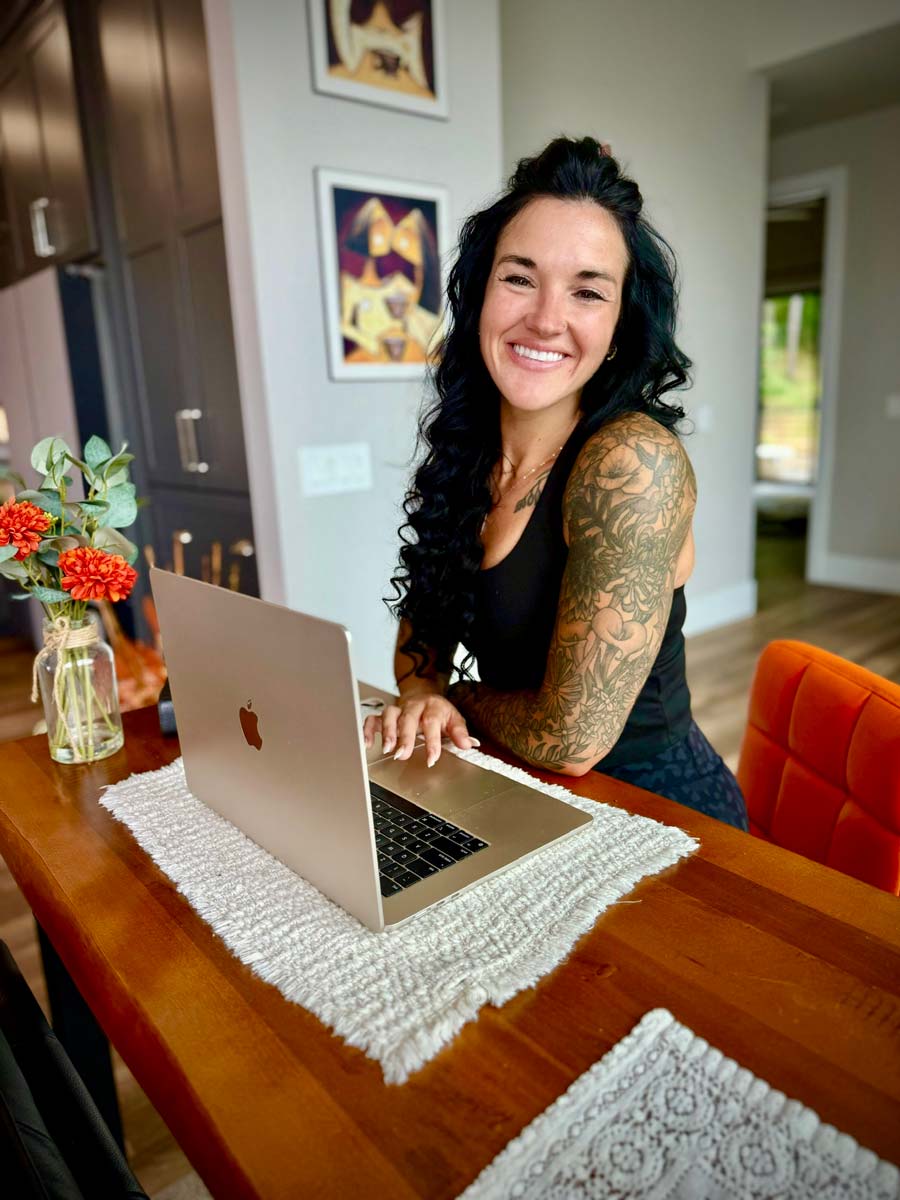 Britt Mudd working on a laptop showing you how to sign up for her coaching